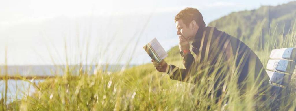 Catalog and publications. A man reading in a field