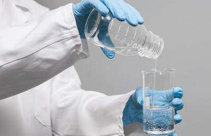 Researcher pouring a liquid into a flask