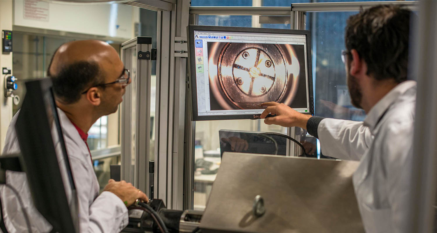 Two researchers observe a screen