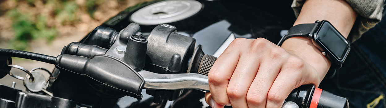 Detalle de una mano pulsando el freno de una moto