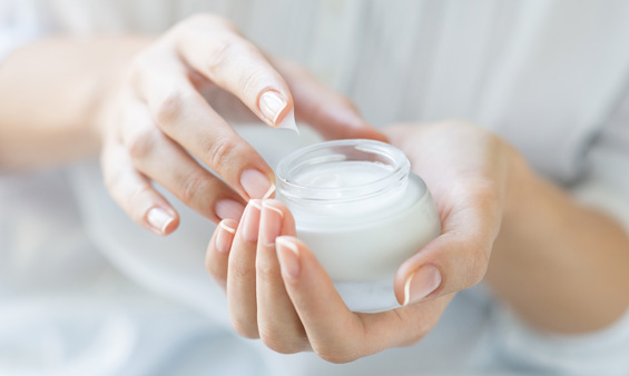 Hands holding a pot of cream