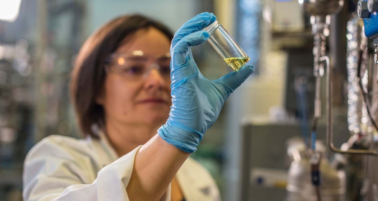 Mujer química observando un líquido amarillo