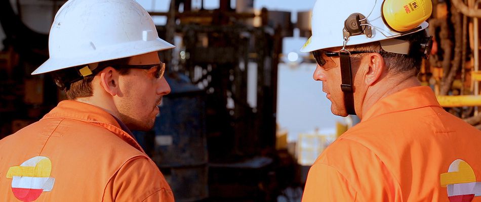 Dos operarios trabajan con sus equipos de seguridad