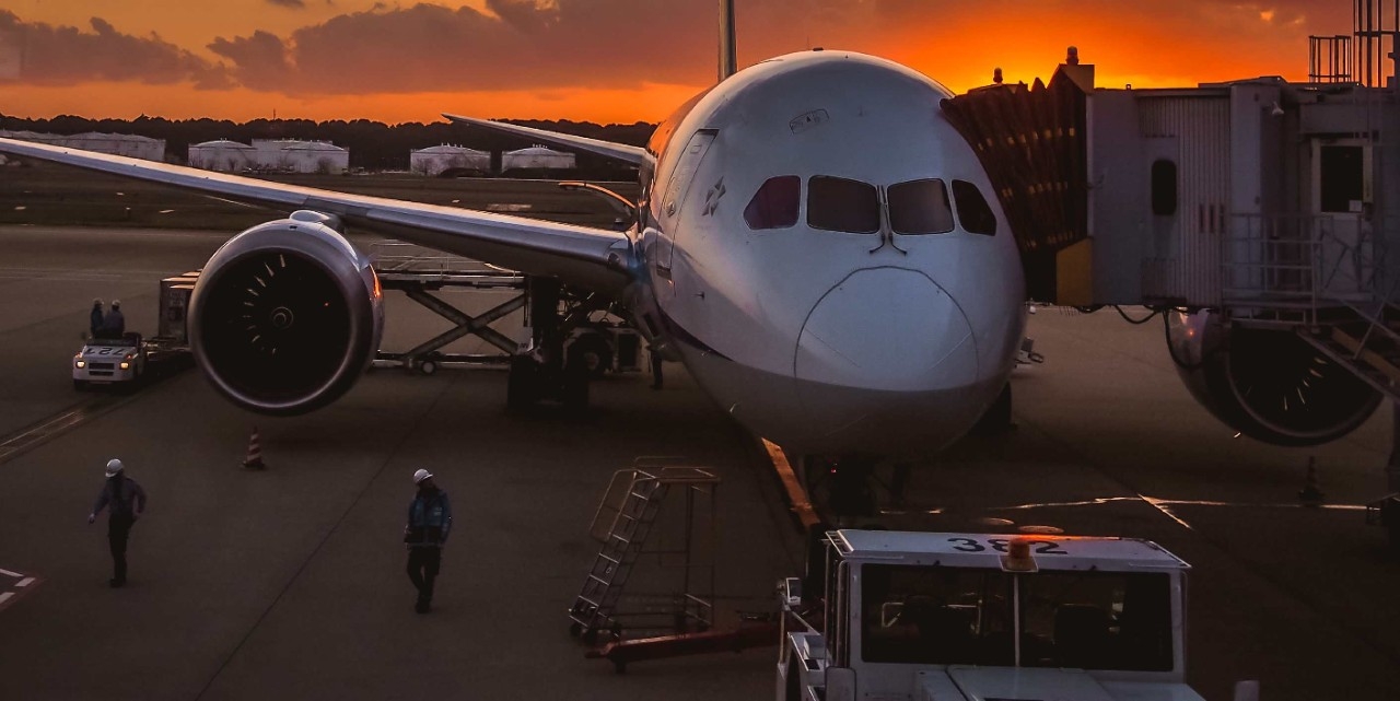 Vista de un avión en un aeropuerto al atardecer.