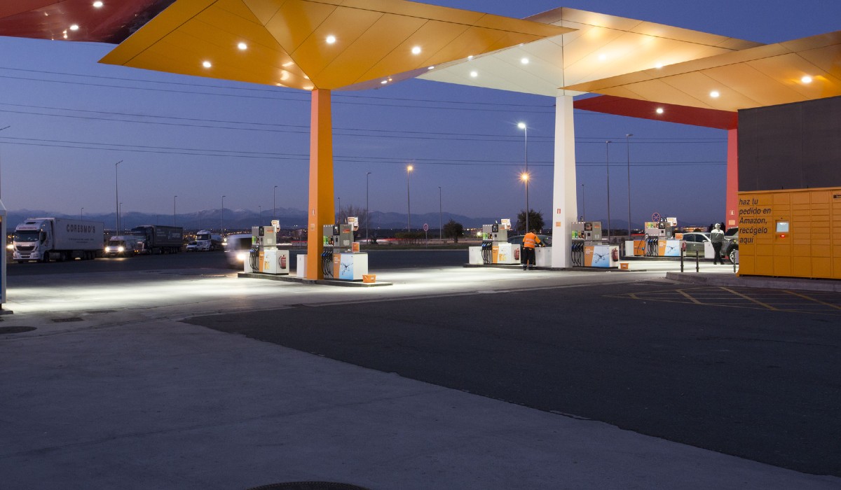 Vista de una estación de servicio Repsol iluminada por la noche 