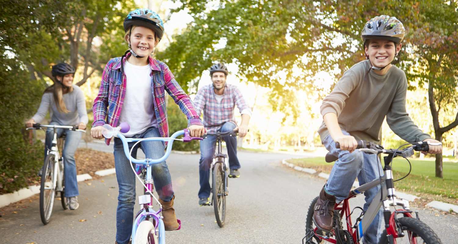 Un hombre y una mujer pasean en bicicleta con sus hijos
