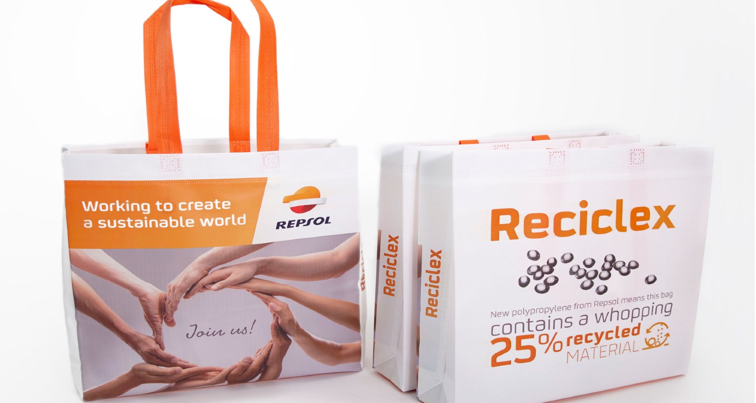 A bag with handles that has Repsol's logo and information about Reciclex