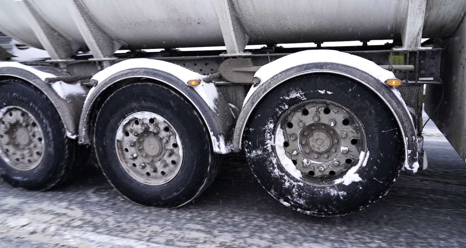 View of three truck wheels covered by snow