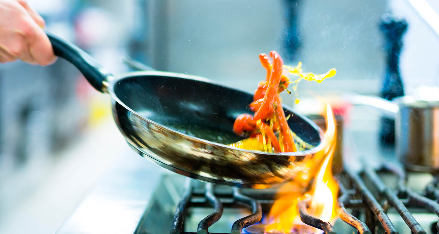 Frying pan with a saut&eacute;ed food on the fire of a stove