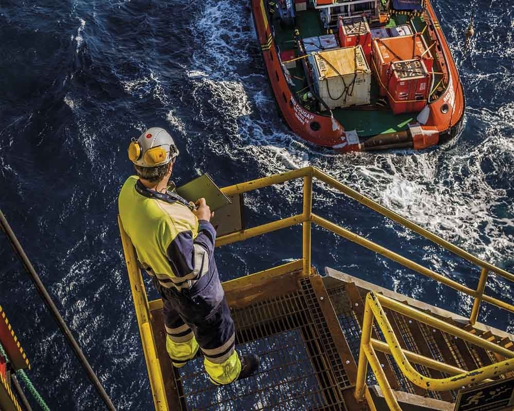 Hombre mira una lancha desde una plataforma