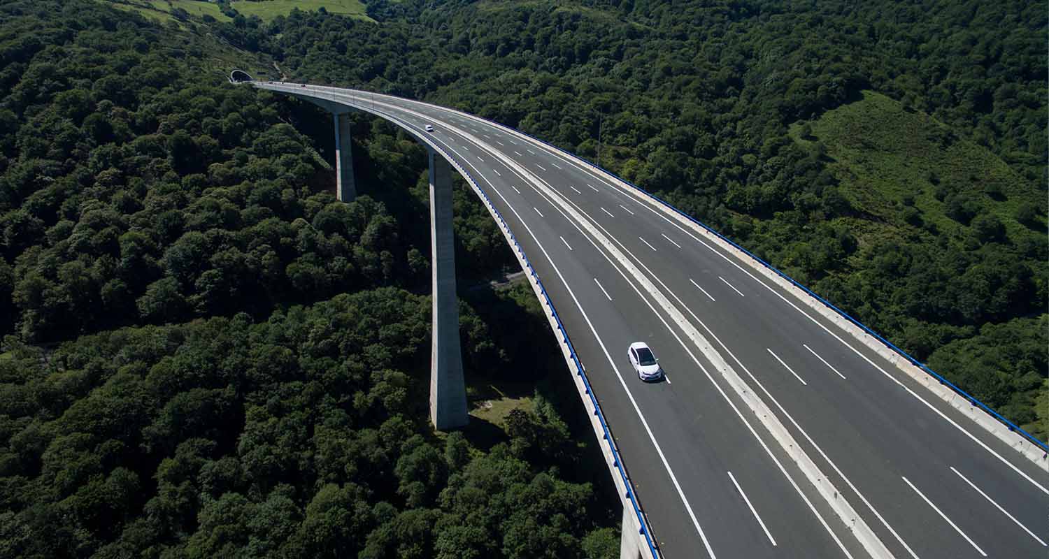 A car on the road surrounded by greenery