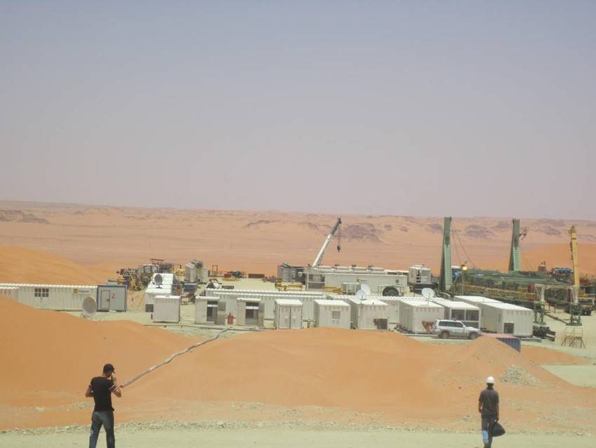 Dos hombres mirando hacia las instalaciones de Repsol en el desierto de Argelia