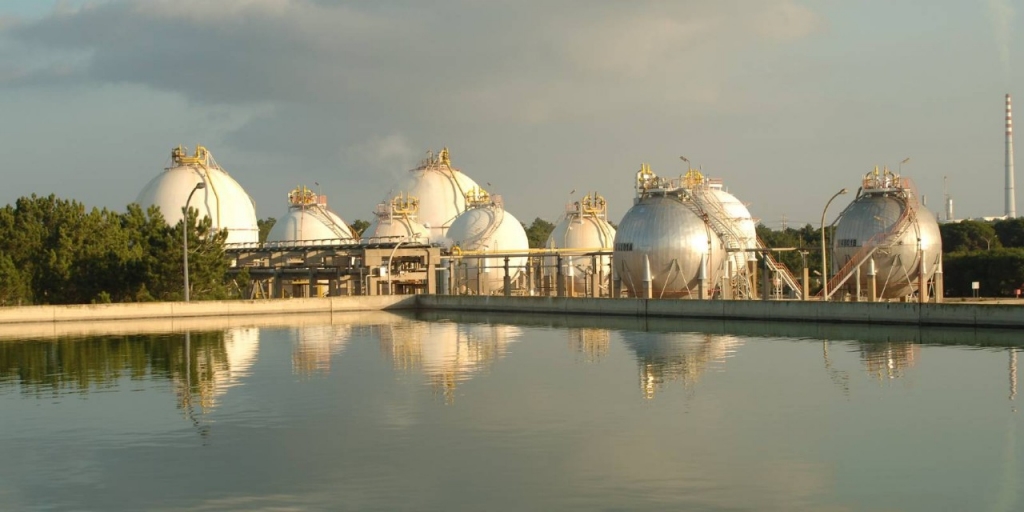 View of an industrial complex next to a reservoir.