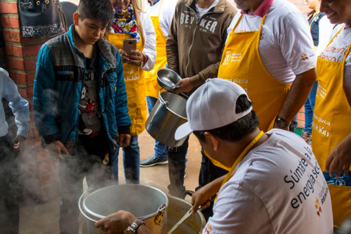 Repsol in Bolivia. Repsol volunteers cooking and serving food 