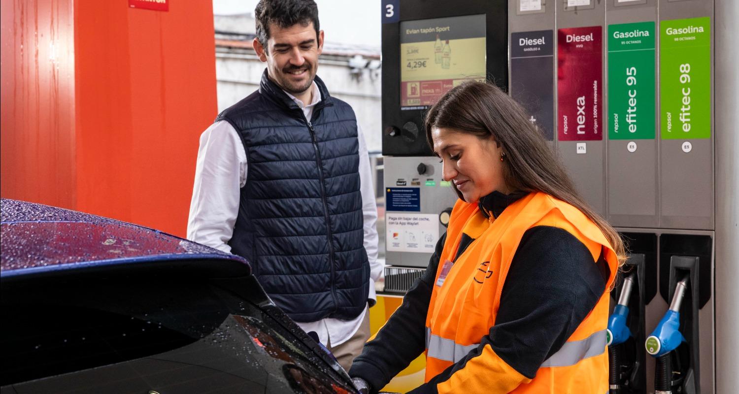 An employee helping a custoemr fill up on renewable fuels.