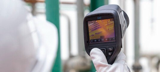  An industrial complex worker consulting a measuring device