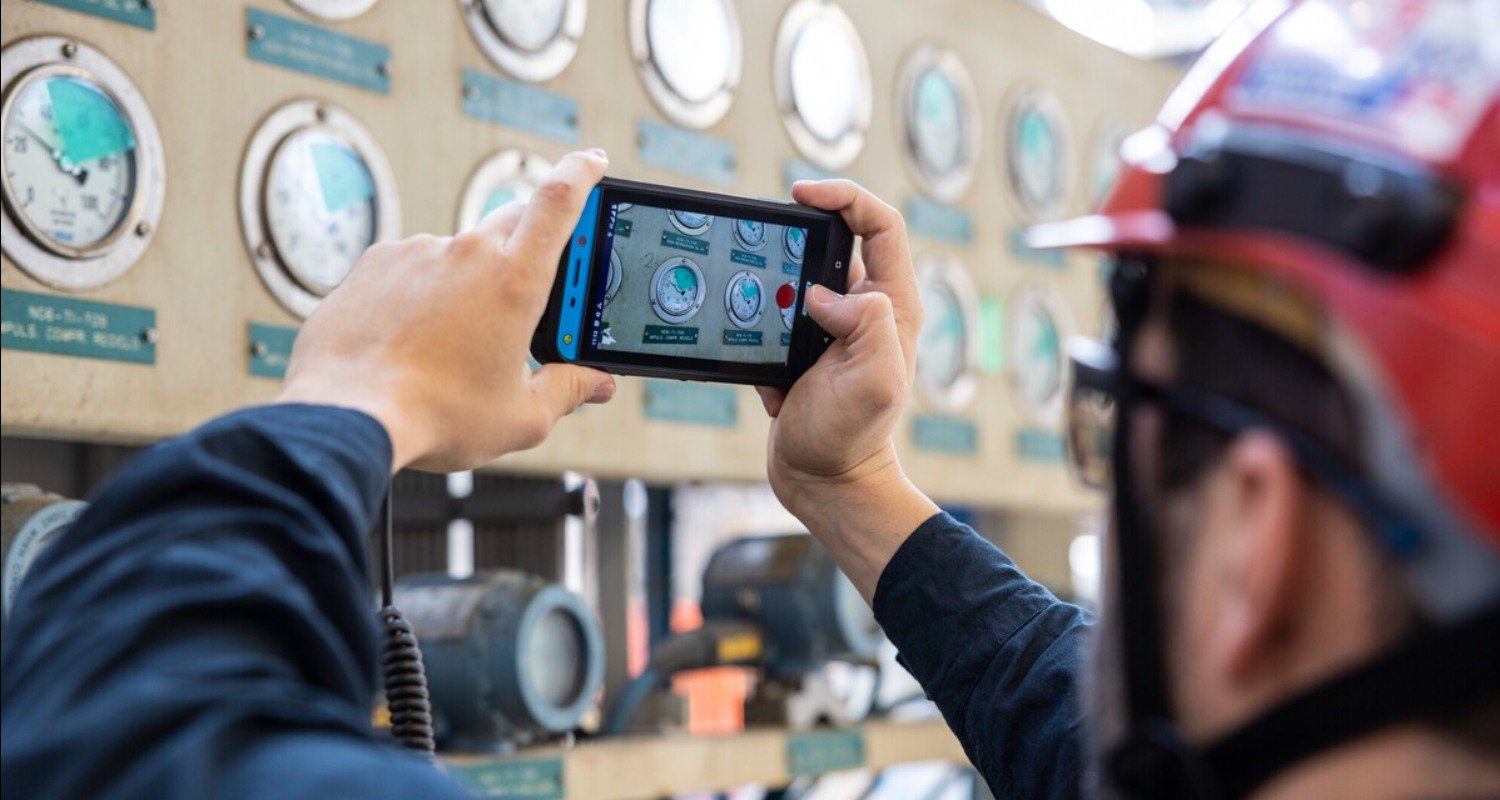 Worker with cellphone monitoring valves