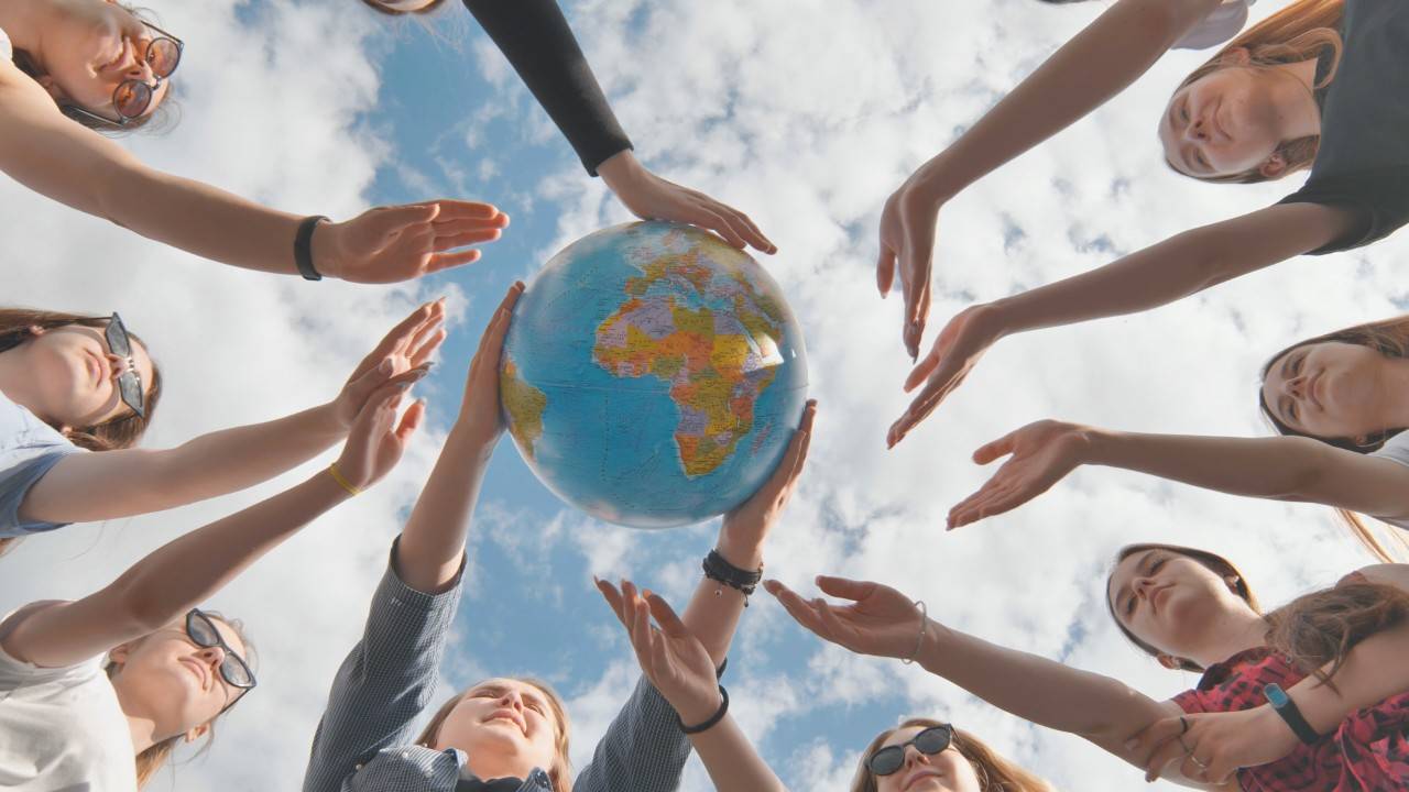 jóvenes sujetando un globo terráqueo, símbolo de la lucha contra el cambio climático