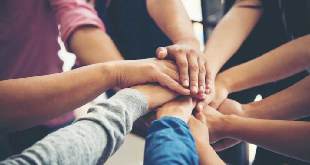 Group of people putting their hands on top of each other