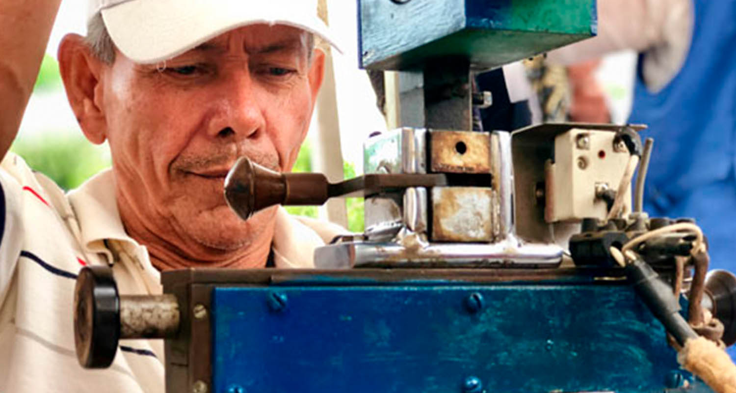 Un hombre realiza un trabajo manipulando una máquina artesanal 