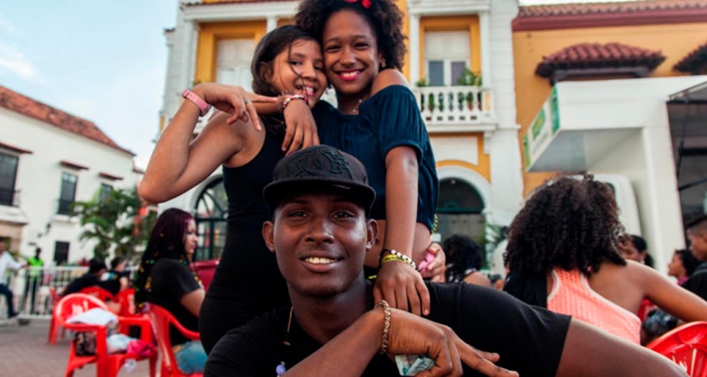 Un chico y dos chicas sonriendo. 