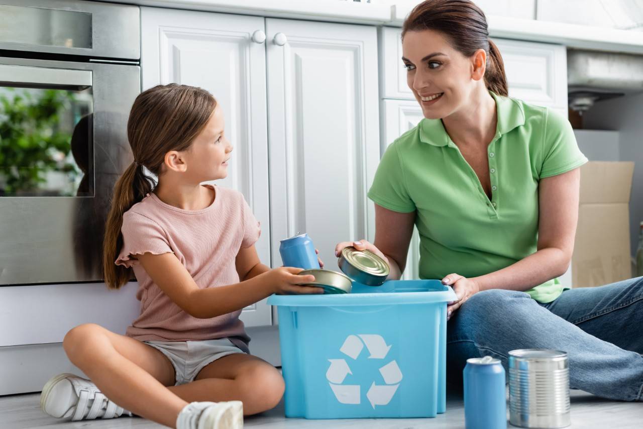 A mother and daughter recycling cans to care for the environment