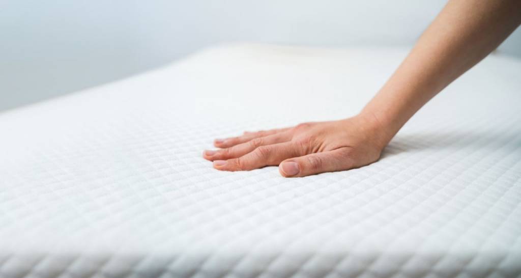 View of a frame of the video showing an image of a hand touching a mattress