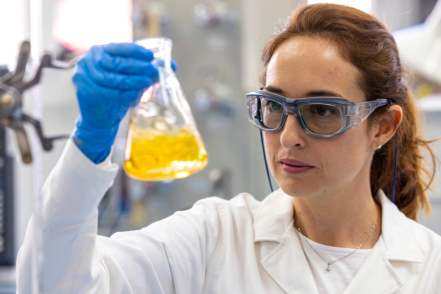 A researcher looking at a beaker