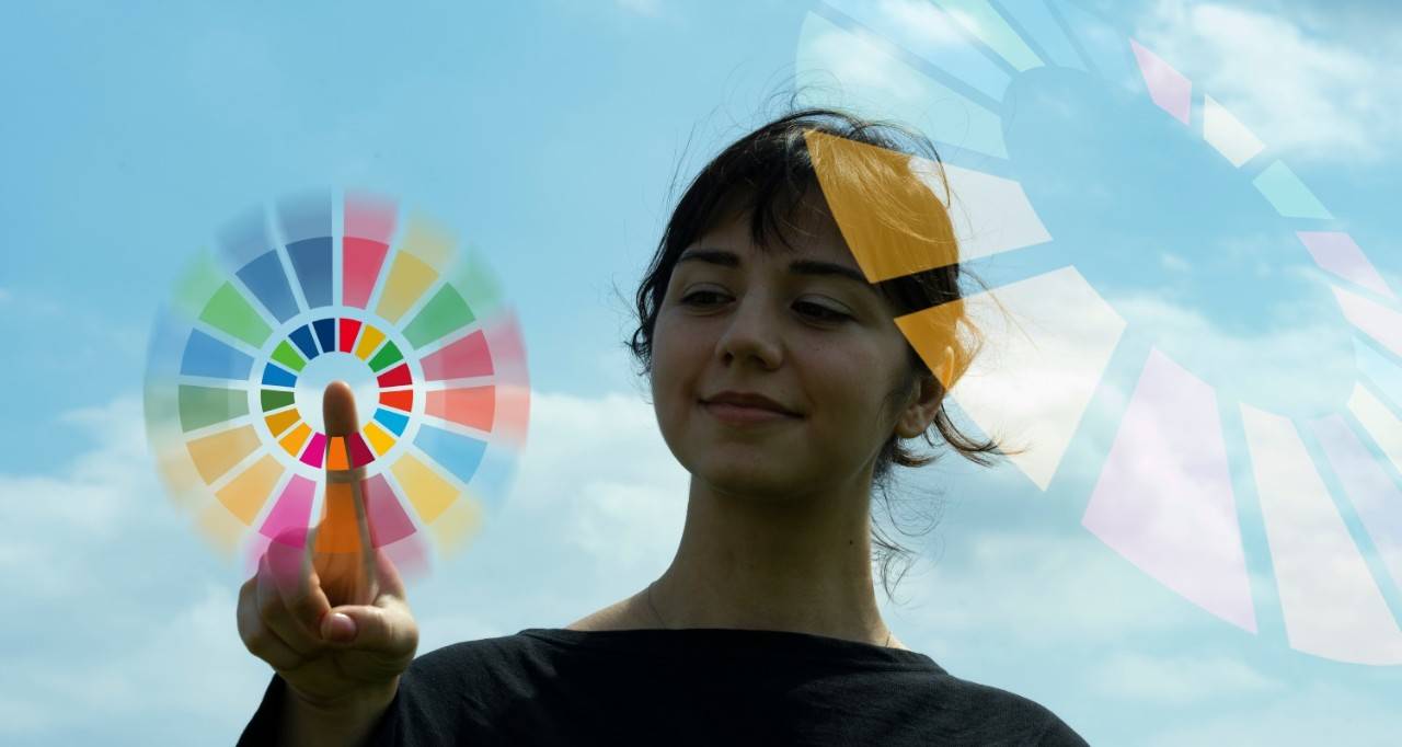 Una mujer con el logo de los ODS