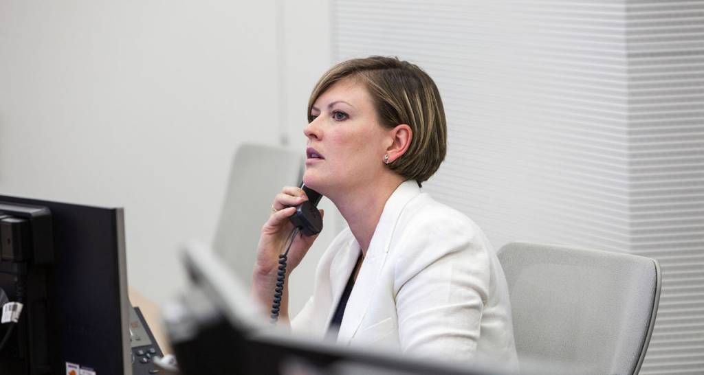 Mujer hablando por teléfono en su mesa de oficina