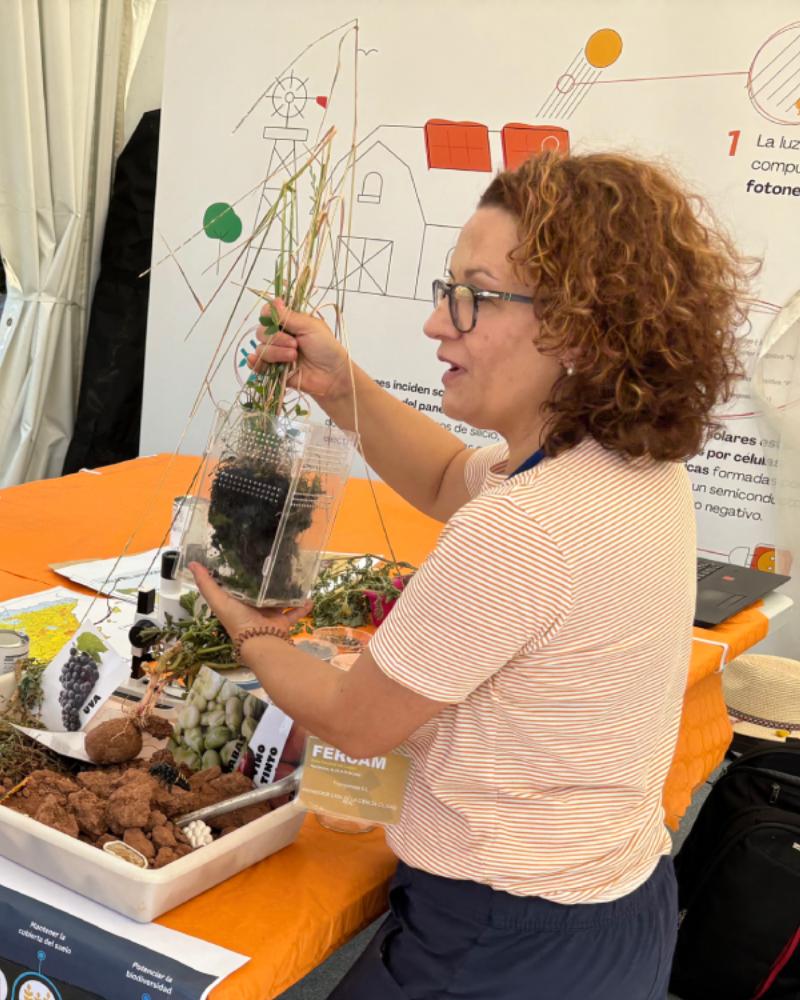 Una mujer en un stand enseñando una planta