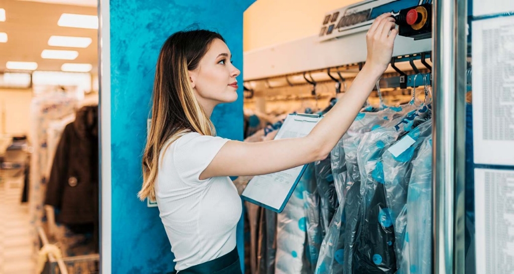 A woman handling clothes stored in film bags.