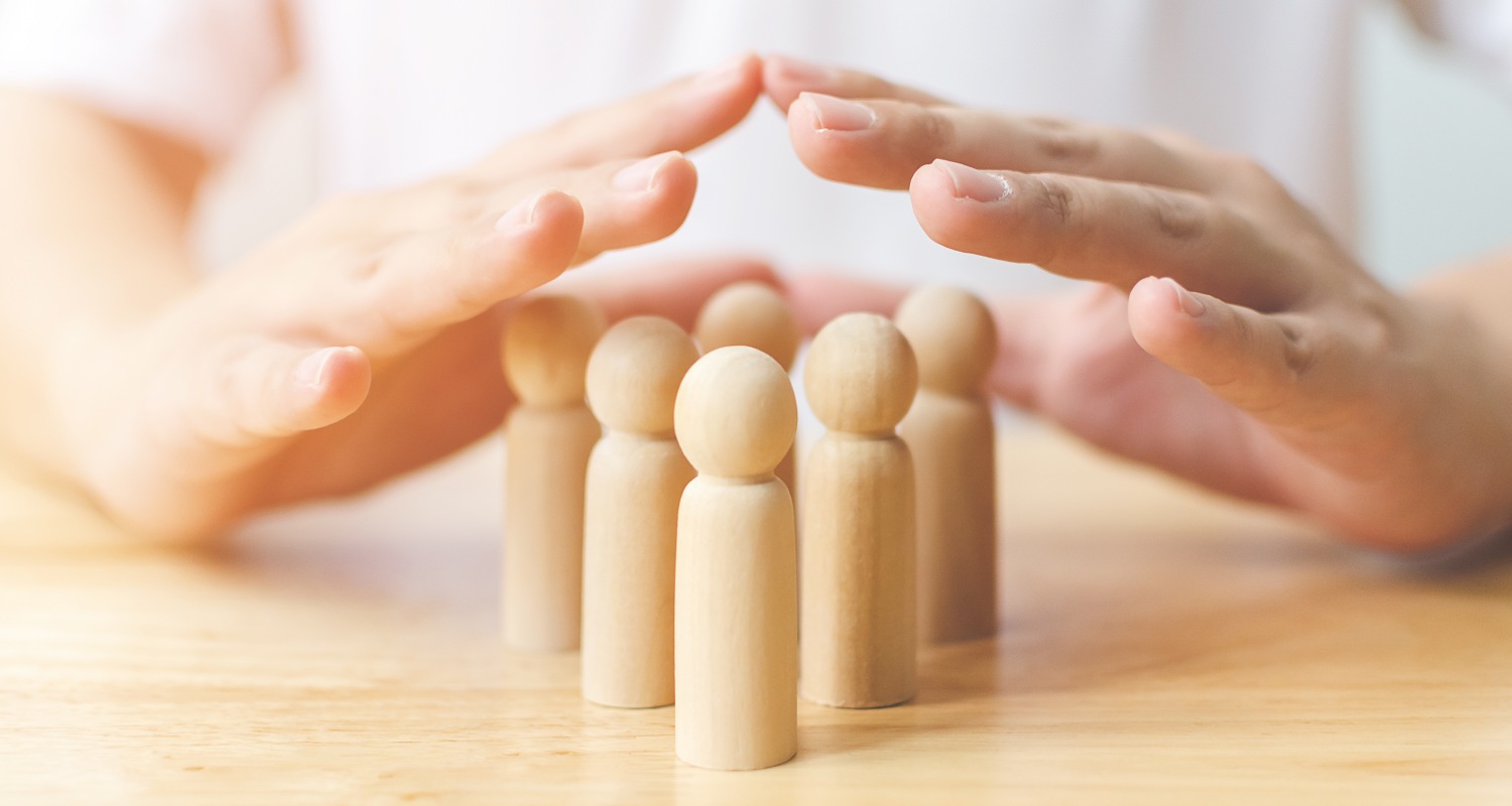 Manos cubriendo figuras de madera