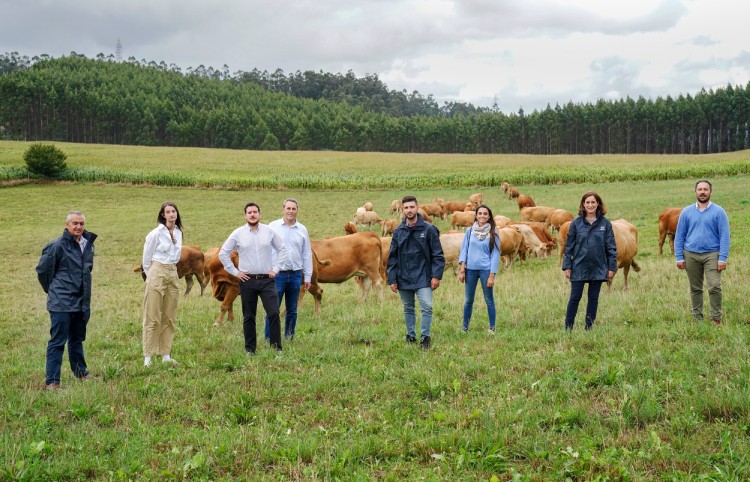 Several people from the project posing in a field with cows in the background