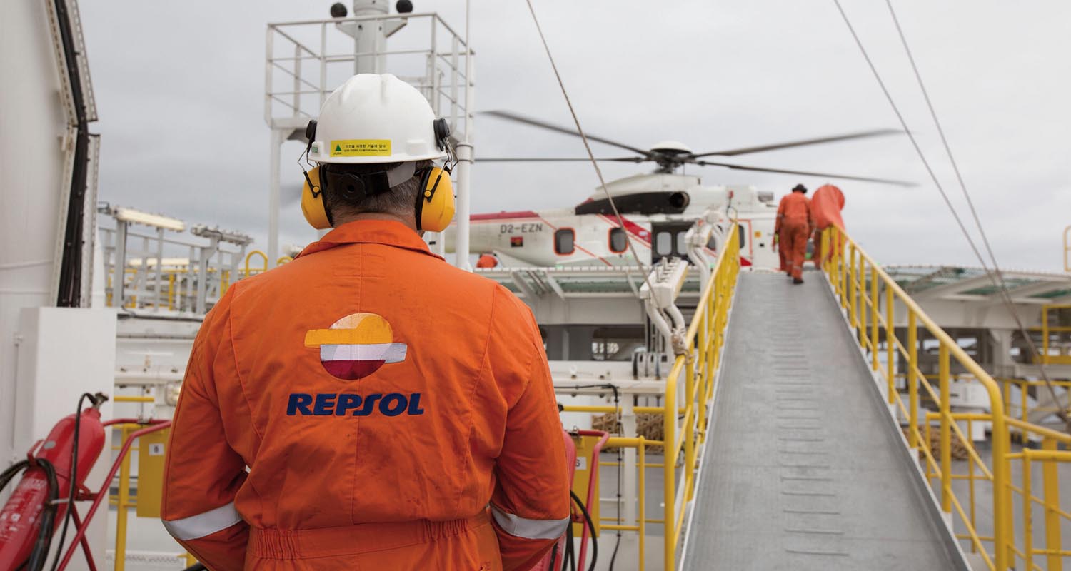 A Repsol employee with his back turned in an outdoor operation.