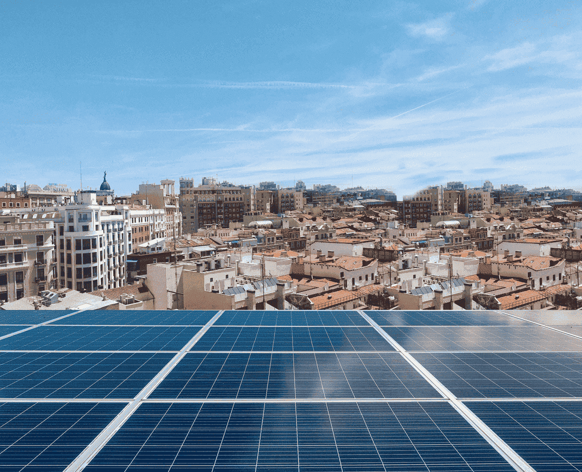 Placas solares con ciudad de fondo